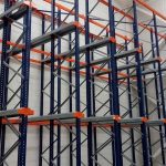Estanterías metálicas industriales de segunda mano con bastidores azules y largueros naranjas en una nave